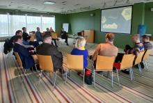 People sitting in a half cirlce looking at a presentation